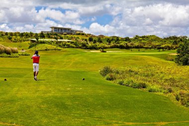Golfçü bir atış yaptı ve topun uçuşunu gözlemledi. Mauritius Adası.