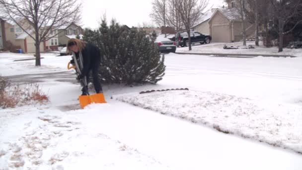 Vrouw die sneeuw schept — Stockvideo