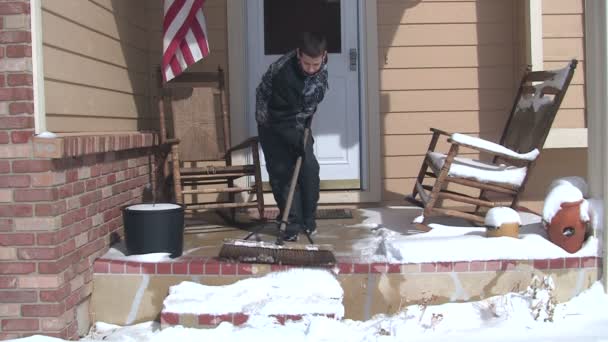 Menino varrendo neve do alpendre — Vídeo de Stock