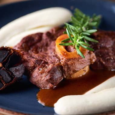 Osso buco, dana inciği. Ossobuco eti. Ahşap bir tahtada, restoranda servis yapmak, menü yemek konsepti.