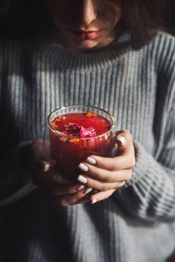 Kırmızı çaydan hoşlanan kız, elindeki fincana odaklan, sade bir anahtarla.