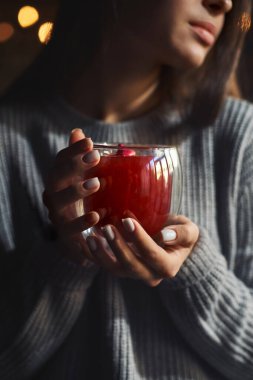 Kırmızı çaydan hoşlanan kız, elindeki fincana odaklan, sade bir anahtarla.