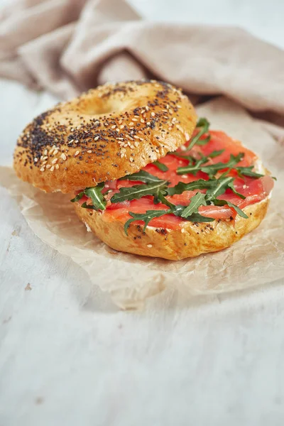 Bagel with salmon and arugula on a table — Stock Photo, Image