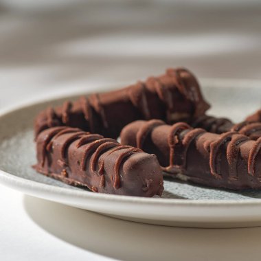 Vegan sugar-free sweets made with nuts, dates and honey.Homemade vegan candy from nuts, dates, seeds, cocoa free sugar on a plate on a white background close-up. Energy balls, raw food