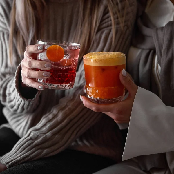 Close-up op een ouderwets glas met een rode cocktail in de handen van een vrouw in knuffelen — Stockfoto