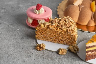 Pastanın çeşitli parçaları. Gri bir arka planda waffle, badem kurabiyesi, çikolatalı kadife pasta. Boşluğu kopyala