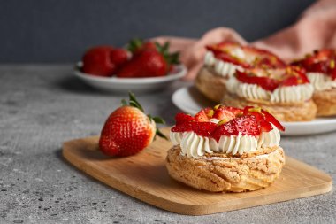 Choux hamur işleri. Craquelin Choux bisküvileri. Kremalı gevrek kremalı ve çilekli..