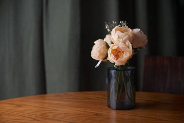 Ahşap masa üzerinde gül buketi olan vazo, metin için alan