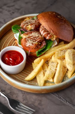 Marullu falafel burger, domates, soğan, patates kızartması, masaya baharatlı sos. Vejetaryen yemekleri lezzetli ve besleyicidir.