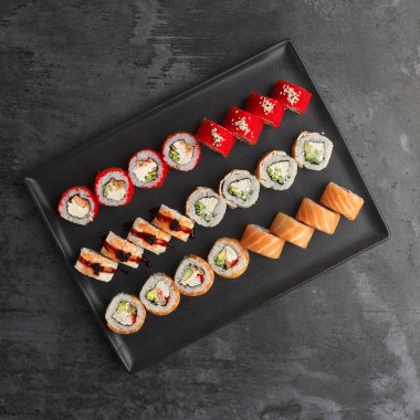 Suşi seti. Philadelphia 'da, Tempura Somon' da, California Red 'de taş zeminde taze malzemeler var. Üst Manzara. Suşi menüsü. Japon yemeği..