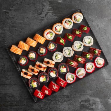 Suşi seti. Philadelphia 'yı, Tempura Ebi' yi, California Red 'i, Tempura Somon' u, yeşil ejderhayı taş zeminde taze malzemelerle yuvarlayın. Üst Manzara. Suşi menüsü. Japon yemeği..