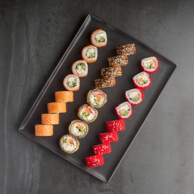 Suşi seti. Philadelphia, California Black 'te taş zeminde taze malzemeler var. Üst Manzara. Suşi menüsü. Japon yemeği..