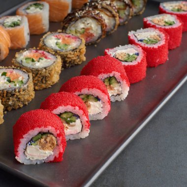 Suşi seti. Philadelphia, California Black 'te taş zeminde taze malzemeler var. Suşi menüsü. Japon yemeği..