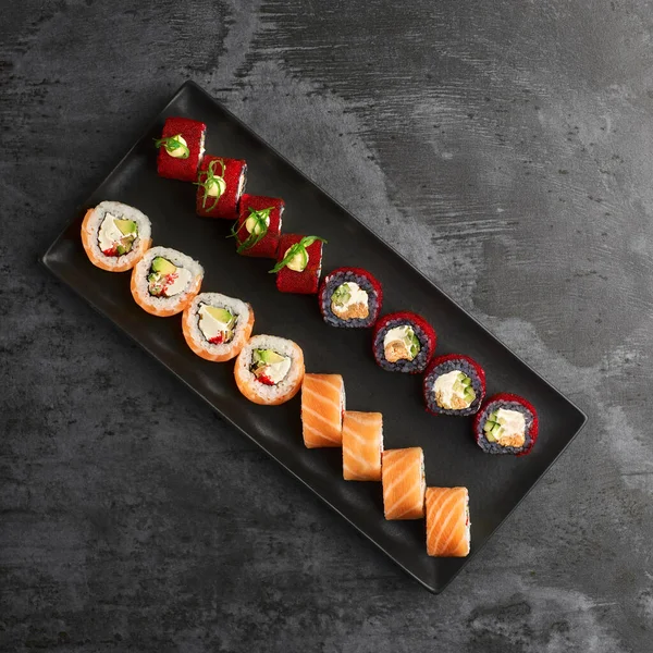 Suşi seti. Philadelphia, California Black 'te taş zeminde taze malzemeler var. Üst Manzara. Suşi menüsü. Japon yemeği..