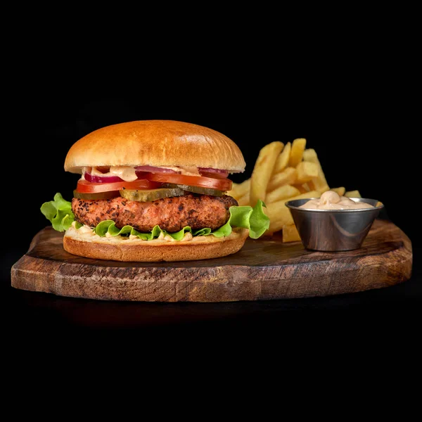 Tahta tepside taze sığır burger ve patates kızartması manzarası. Hamburger siyah arkaplanda izole edildi.
