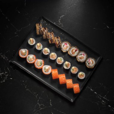 Suşi seti ve taş zeminde taze malzemeler. Üst Manzara. Suşi menüsü. Japon yemeği..