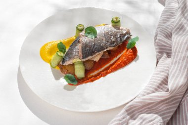 Balık yemeği, gökkuşağı kremalı Dorado. Dorado filetosu, garnitür, yeşillik ve limonlu. Restoran menüsü için beyaz arka planda seramik tabak. Boşluğu kopyala