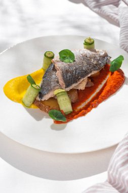 Balık yemeği, gökkuşağı kremalı Dorado. Dorado fileto, garnitür, yeşillik ve limon. Beyaz arka planda seramik tabakta, restoran menüsü için..
