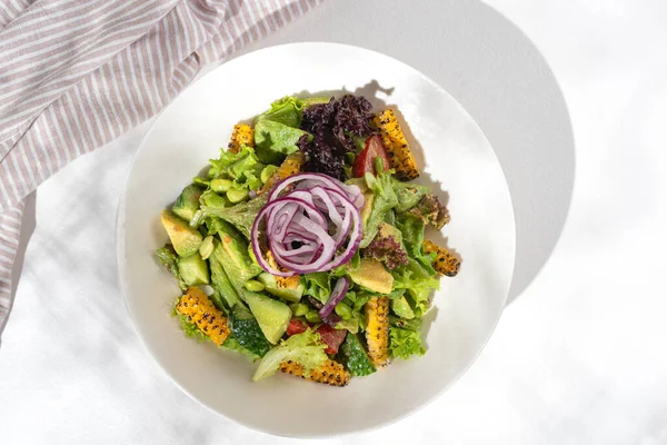Healthy food Salad with edamame and avocado vegetables, edamame beans, bell peppers, corn, cucumbers, tomatoes, red onions on white background for restaurant menu.