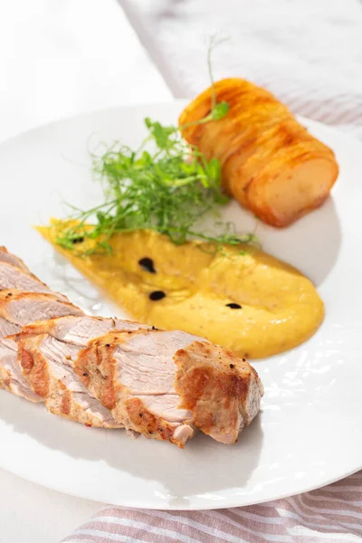 Pork tenderloin with baked potato pave on a white plate. Close up,Selective focus. Healthy concept, menu.