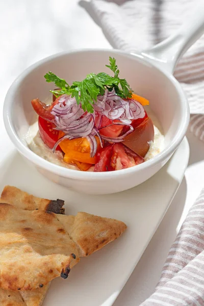 Appetizer. Vegetable salad: greek yogurt with cream cheese, tomatoes on white background for restaurant menu.