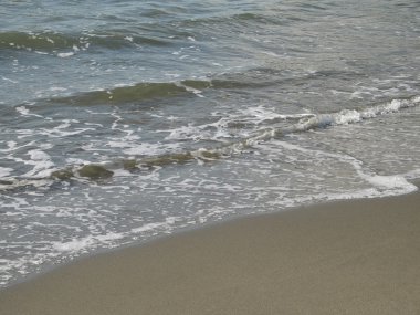 Sandy plaj kıyısında, köpüklü su yıkama