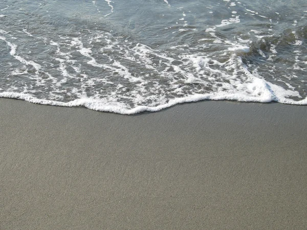 Habos víz lemossa a Sandy Beach partján — Stock Fotó