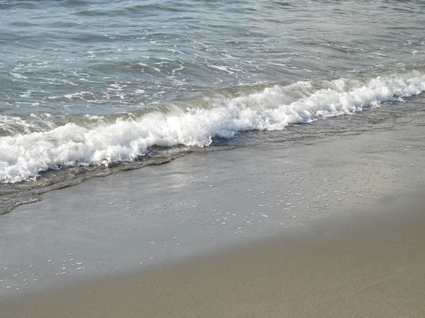 Αφρώδες νερό πλύσεις σε σε μια αμμώδη παραλία Ακτή — Φωτογραφία Αρχείου