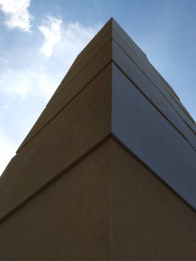 Mavi gökyüzüne karşı bina köşesi, dikey endüstriyel fotoğraf