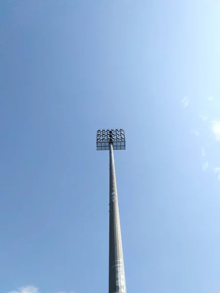 Alto riflettore con scale sul campo di calcio contro il cielo — Foto Stock