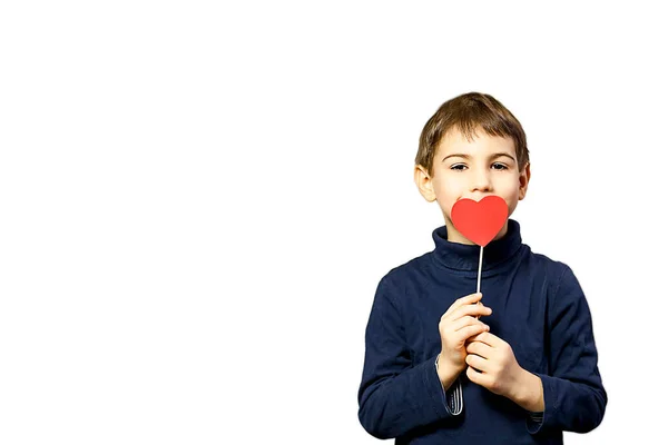 Kid boy with red paper heart standing on white background. Empty space for text. Concept for valentines day.