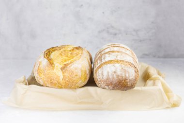 Gri arka planda el işi kağıdında taze ekmek. Seçici odaklanma. Ön görünüm.