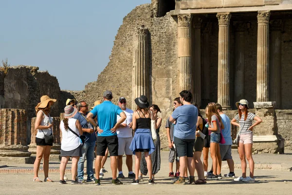 Pompeii, İtalya - Ağustos 2019: Pompeii 'nin tarihini anlatan bir tur rehberini dinleyen bir grup insan