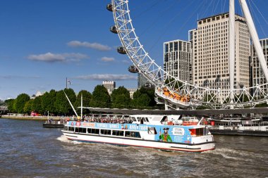 Londra, İngiltere - Ağustos 2021: Londra 'nın merkezindeki Thames Nehri üzerinde Londra Gözü' nden geçen turistik gezi teknesi