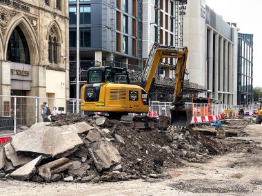 Cardiff, Wales - Eylül 2021: Geliştirme çalışmaları kapsamında Cardiff şehir merkezinde bir moloz yığınının tepesindeki mekanik kazıcı.