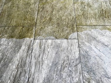 Basınçlı yıkamadan sonra bahçe avlusundaki temiz ve kirli kaldırım levhalarının aksine. İnsan yok. Boşluğu kopyala.