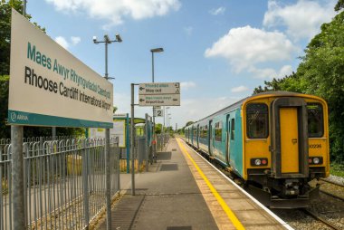 Rhoose, Wales - Haziran 2018: Yolcu treni Rodos köyündeki tren istasyonunda durdu. İstasyondan Cardiff Uluslararası Havaalanına giden bir servis otobüsü var..