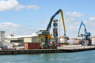 Poole, Dorset, İngiltere - Haziran 2021: Poole limanında kovaları olan büyük mobil vinçler.