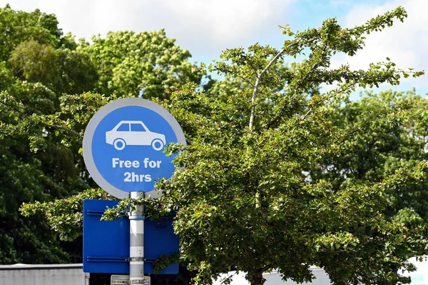 Round sign with car symbol showing a parking area which is free of charge for 24 hours. No people.