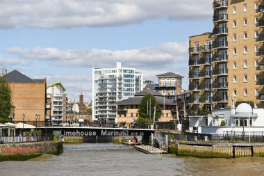 Londra, İngiltere - Haziran 2021: İnsanlar Canary Wharf yakınlarındaki bir apartman kanalı üzerinden köprüden geçiyor