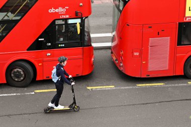 Londra, İngiltere - Haziran 2021: Londra şehir merkezindeki bir yolda elektromanyetik scooter kullanan bir kişinin hava görüntüsü