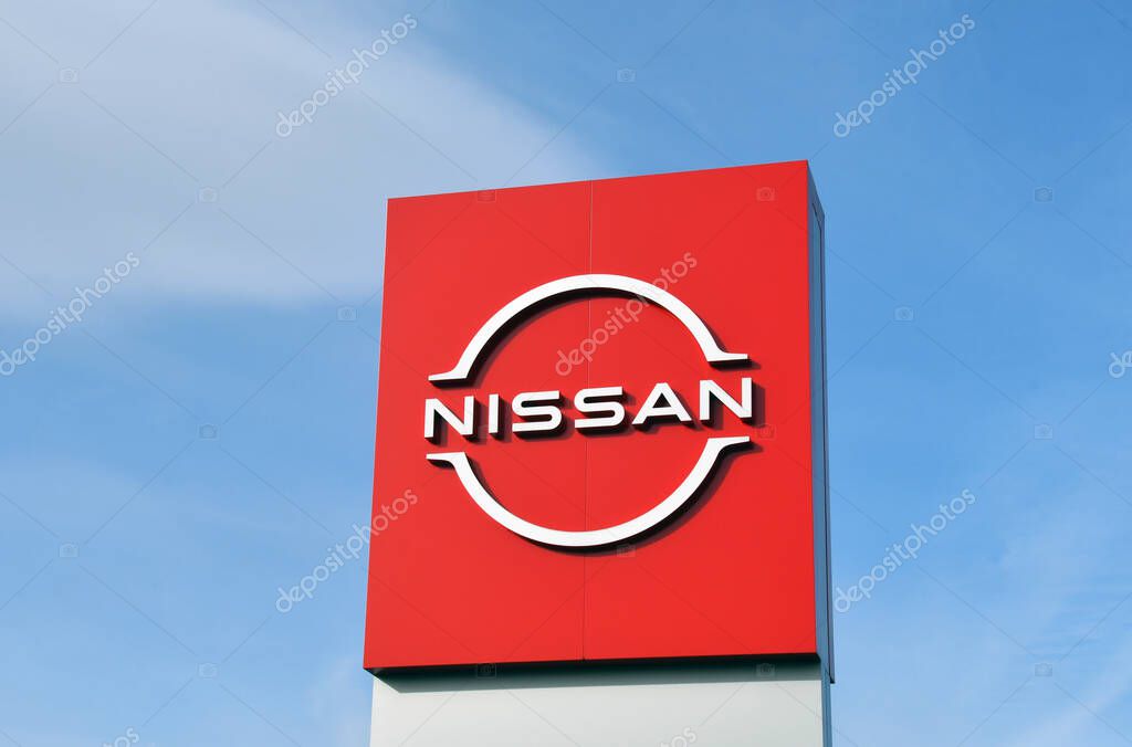 Pontypridd, Wales - February 2022: Sign outside a Nissan car showroom isolated against a blue sky. No people.