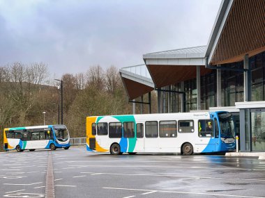 Merthyr Tydfil, Galler - Şubat 2022: Şehir merkezindeki yeni otobüs durağının dışındaki otobüsler