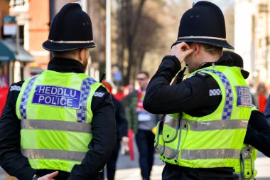 Cardiff, Wales - Mart 2022: Cardiff şehir merkezinde görevli iki polis memurunun arka görüşü