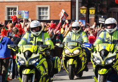 Cardiff, Wales - Mart 2022: Cardiff şehir merkezinde kalabalığın arasından geçen üç polis motosikletlisi