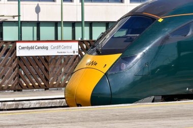 Cardiff, Wales - Mart 2022: 800 sınıfı yüksek hızlı tren Cardiff Central tren istasyonunun platformlarından birinde Great Western demiryolu tarafından işletilmektedir. Arka planda bir istasyon adı işareti var.