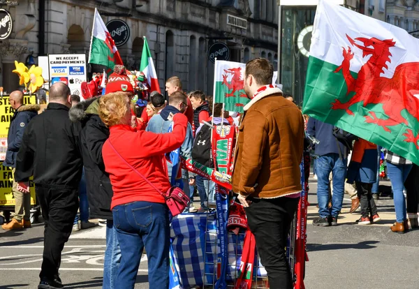 Cardiff, Wales - Mart 2022: Rugby taraftarı maç günü Cardiff şehir merkezindeki bir sokak tüccarından hediye alıyor