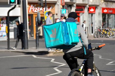 Cardiff, Wales - Mart 2022: Teslimat gıda dağıtım servisi için şehir merkezinden geçen bisikletli kurye