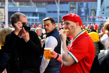 Cardiff, Wales - Mart 2022: Rugby taraftarı bir şeyler yiyor ve uluslararası bir maç öncesinde şehir merkezindeki bir sokakta bira içiyor.