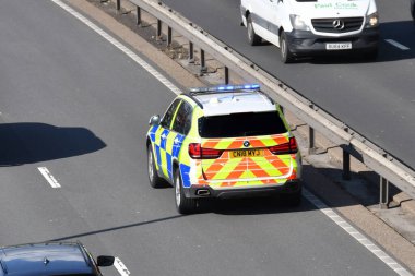 Cardiff, Wales - Mart 2022: Mavi ışıkları yanıp sönen ana yolun hızlı şeridinde giden polis arabası.